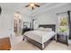 Bright main bedroom with tray ceiling, ceiling fan, neutral walls, and en suite bathroom at 101 Briargate Look, Ormond Beach, FL 32174