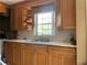 Traditional kitchen features wood cabinets, tiled backsplash and neutral countertops with an eat-in kitchen area at 1025 Persian St, Deltona, FL 32725