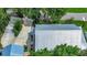 Modern home featuring a sleek metal roof, long driveway, and lush surrounding greenery at 1056 Stevens St, Lake Helen, FL 32744