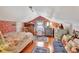 Unique attic bedroom features eye catching wallpaper, hardwood floors, a bed, and a seating area, all bathed in natural light at 1056 Stevens St, Lake Helen, FL 32744
