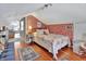 Charming attic bedroom offers colorful wallpaper, hardwood floors, a bed, and ample natural light in a cozy setting at 1056 Stevens St, Lake Helen, FL 32744