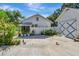 Charming backyard with white house, fence, blue door accents, and beautiful potted plants at 1056 Stevens St, Lake Helen, FL 32744