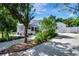 Charming home surrounded by lush landscaping, featuring a white exterior and a long driveway leading to a detached garage at 1056 Stevens St, Lake Helen, FL 32744