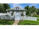 Charming home featuring a white picket fence, stone pathway, and well-manicured lawn at 1056 Stevens St, Lake Helen, FL 32744