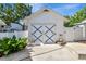 Garage with white siding and blue 'X' design on the doors in fenced backyard at 1056 Stevens St, Lake Helen, FL 32744