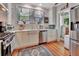 Well-lit kitchen featuring stainless steel appliances, white cabinetry, and a farmhouse sink, blending modern amenities with classic charm at 1056 Stevens St, Lake Helen, FL 32744