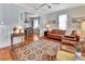 Bright living room showcasing hardwood floors, a classic ceiling fan, and a cozy seating area with leather sofas at 1056 Stevens St, Lake Helen, FL 32744