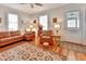 Cozy living room with leather sofa and chair, featuring a ceiling fan and hardwood floors at 1056 Stevens St, Lake Helen, FL 32744