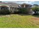 Lawn of a single Gathering home with mature landscaping and an attached two car garage at 1118 Prescott Blvd, Deltona, FL 32738