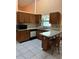 Functional kitchen with wood cabinets, granite countertops, and convenient breakfast bar at 1118 Prescott Blvd, Deltona, FL 32738