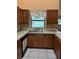 Functional kitchen featuring wood cabinets, granite countertops, and stainless steel sink at 1118 Prescott Blvd, Deltona, FL 32738