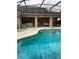 Large screened-in pool with an attached porch with chairs and a swing for relaxing and outdoor living at 1118 Prescott Blvd, Deltona, FL 32738