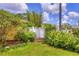 Lush backyard featuring a decorative white fence, verdant plantings and blooming flowers at 1131 Lemonwood Ave, Deland, FL 32724