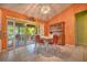 An orange dining room, with vintage table and chairs, and a glass slider to the patio at 1131 Lemonwood Ave, Deland, FL 32724