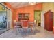 The dining room boasts an orange color, vintage table and chairs, and a glass slider to the patio at 1131 Lemonwood Ave, Deland, FL 32724