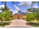 Inviting yellow home with a red front door, solar panels and lush tropical landscaping at 1131 Lemonwood Ave, Deland, FL 32724
