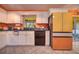 A well-lit kitchen featuring modern appliances, granite countertops, white cabinets, tile floors, and backyard view at 1131 Lemonwood Ave, Deland, FL 32724