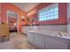 The main bathroom includes a soaking tub with glass block window, double vanities, and tiled floors at 1131 Lemonwood Ave, Deland, FL 32724
