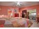 Main bedroom features a colorful quilt, ceiling fan, sliding glass door to patio, and an ensuite bathroom at 1131 Lemonwood Ave, Deland, FL 32724