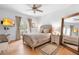 This bright bedroom boasts a private balcony, ceiling fan, and elegant decor at 1155 Taylor E Rd, Deland, FL 32724