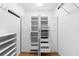 Walk-in closet features white cabinets with drawers, shelving, and closet rod for optimal storage at 1155 Taylor E Rd, Deland, FL 32724