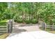 Gated driveway leads to a large, luxurious home partially obscured by mature trees at 1155 Taylor E Rd, Deland, FL 32724