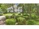 Manicured landscaping surrounds a two-story home with columns, visible through trees at 1155 Taylor E Rd, Deland, FL 32724