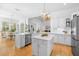 The expansive white kitchen features stainless steel appliances, a large island, and an adjacent dining area at 1155 Taylor E Rd, Deland, FL 32724
