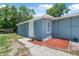 Exterior of a light-blue home with a small backyard area and landscaped features at 1214 Flomich St, Daytona Beach, FL 32117