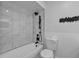 Modern bathroom featuring marble-look tile surround and black shower fixtures at 1214 Flomich St, Daytona Beach, FL 32117