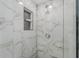 A modern shower with white marble-patterned tile and a built-in shelf at 1214 Flomich St, Daytona Beach, FL 32117