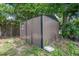View of the metal storage shed located in the backyard of the home and surrounded by green foliage at 1214 Flomich St, Daytona Beach, FL 32117