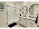 Modern bathroom with double vanity, granite countertops, framed mirrors, and a large glass-enclosed shower at 1216 August Sky Dr, Deltona, FL 32738