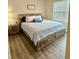 Comfortable bedroom with a queen-size bed, wood-look flooring, and a nightstand with bedside lamp, creating a relaxing retreat at 1216 August Sky Dr, Deltona, FL 32738