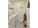 Functional laundry area features a washer, dryer, shelving, and white walls at 1216 August Sky Dr, Deltona, FL 32738