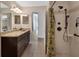 Bathroom featuring granite counters, dark cabinets, tile flooring, and walk-in shower for a luxurious experience at 1329 Sunningdale Ln, Ormond Beach, FL 32174