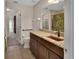 Bathroom with dark cabinets, granite counters, tile flooring, and accessible features, enhancing comfort and style at 1329 Sunningdale Ln, Ormond Beach, FL 32174