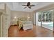 Inviting bedroom with hardwood floors, a cozy floral bed, and sliding door access to the outdoor area at 1329 Sunningdale Ln, Ormond Beach, FL 32174