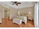 Comfortable bedroom featuring hardwood floors, neutral walls, a floral bedspread, and an adjacent bathroom at 1329 Sunningdale Ln, Ormond Beach, FL 32174