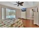Bright bedroom with hardwood floors, a floral patterned bed, and sliding glass doors leading to a refreshing pool area at 1329 Sunningdale Ln, Ormond Beach, FL 32174