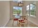 Bright dining area with a glass table, white chairs, and large windows offering scenic views at 1329 Sunningdale Ln, Ormond Beach, FL 32174