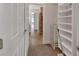 Hallway featuring walk-in closet with custom shelving and racks, and tile flooring at 1329 Sunningdale Ln, Ormond Beach, FL 32174