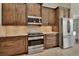 Stylish kitchen featuring stainless steel appliances, granite countertops, and dark wood cabinets for a modern look at 1329 Sunningdale Ln, Ormond Beach, FL 32174