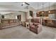 Open-concept living space with plush seating, neutral carpeting, and a view into the kitchen area at 1329 Sunningdale Ln, Ormond Beach, FL 32174