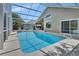 A screened-in pool features a large pool with an attached spa and outdoor kitchen on a large lanai at 1329 Sunningdale Ln, Ormond Beach, FL 32174