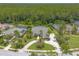 Overhead view of the house showing off its circular driveway, mature landscaping, and proximity to a green space at 15 Cambridge Trce, Ormond Beach, FL 32174