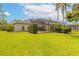 Well maintained lawn and exterior of home, screened in pool enclosure visible at 15 Cambridge Trce, Ormond Beach, FL 32174