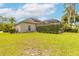 Backyard of home, showing manicured lawn and screened in pool enclosure at 15 Cambridge Trce, Ormond Beach, FL 32174