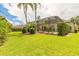 Expansive backyard featuring lush green grass, mature trees, and a screened-in patio area at 15 Cambridge Trce, Ormond Beach, FL 32174