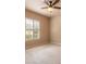 Comfortable bedroom with neutral carpet, a ceiling fan and a window looking out onto the property at 15 Cambridge Trce, Ormond Beach, FL 32174
